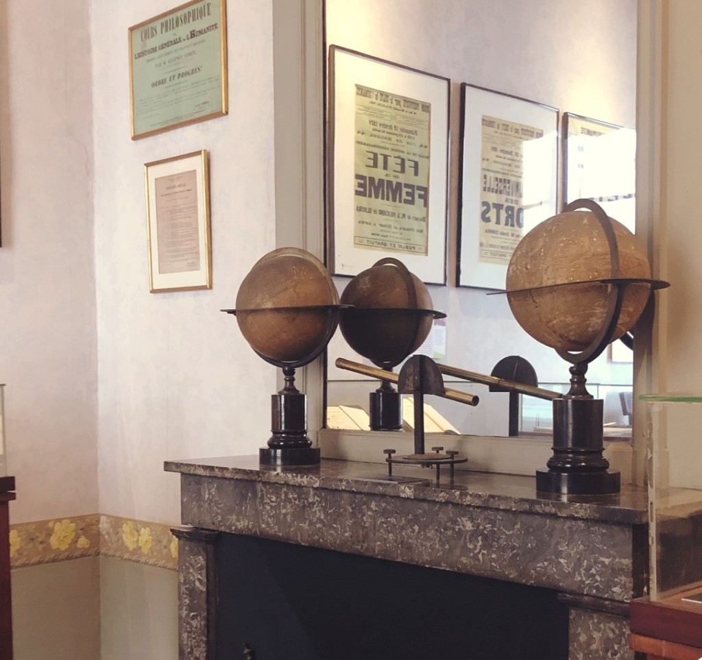 Close up of globes, documents and mirror on a marble mantlepiece